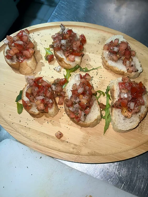 Bruschetta mit Tomaten auf Holzbrett